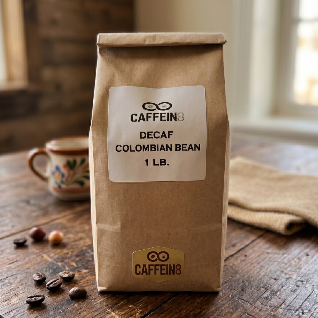CAFFEIN8 Decaf Colombian Bean coffee, 1 lb kraft bag, on a rustic wood table with a mug and coffee beans