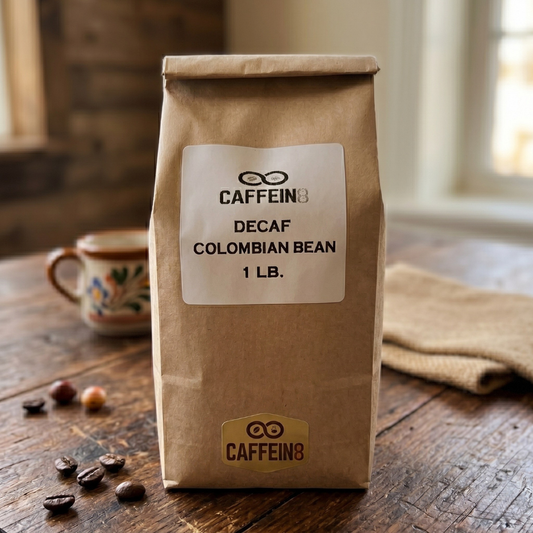 CAFFEIN8 Decaf Colombian Bean coffee, 1 lb kraft bag, on a rustic wood table with a mug and coffee beans
