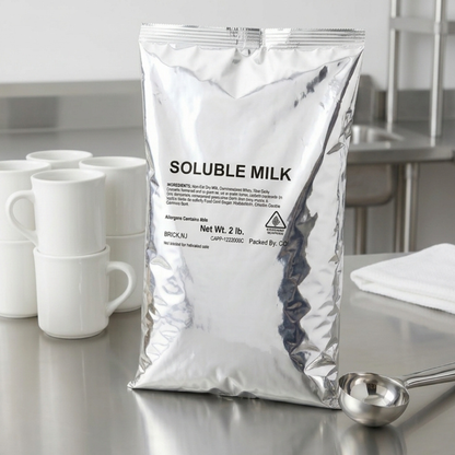 CAFFEIN8 Original Powdered Milk 2 lb bag on a breakroom counter with coffee mugs and measuring scoop