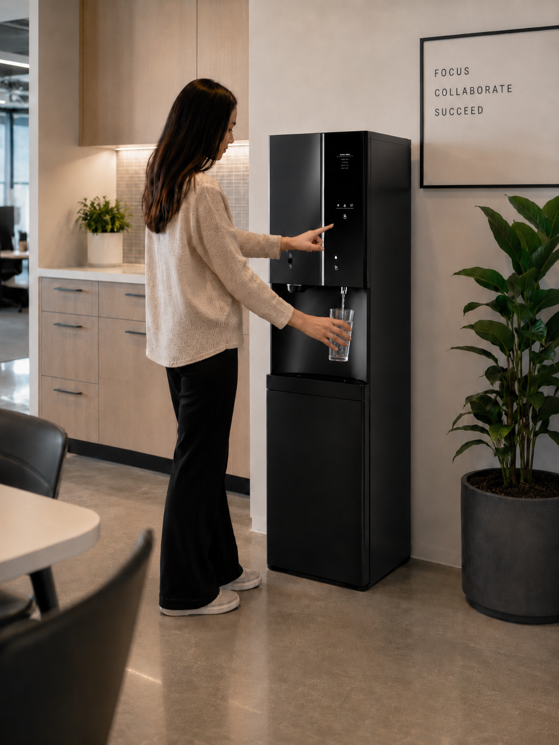 Woman filling a glass with filtered water from a HYDR8 iCHILL freestanding dispenser