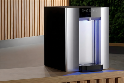 HYDR8 premium countertop water dispenser with a blue-lit dispense area on a wood counter